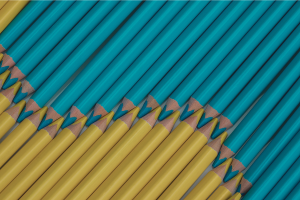 Yellow and aqua colored pencils arranged in wave design.