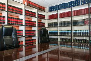 Conference table with open chairs surrounded by shelves of books.