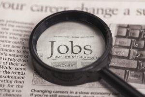 Magnifying glass on newspaper over the word Jobs.