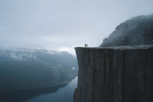 Photograph of two individuals on a cliff.