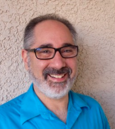 Headshot of Ari Kaufman in a sky blue polo shirt.