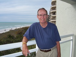 Photo of an older male wearing a blue t-short tucked into beige pants. 