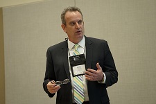 Photo of former AACRAO executive director, Mike V. Reilly, speaking while dressed in a suit and tie.