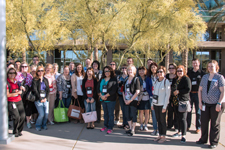 Large group photo of people standing outside on a sunny day.