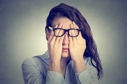 Female wipes her face presumably out of stress or anguish.