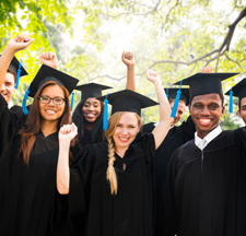 Group of students wearing graduation caps with a blue tassel and black gowns. 