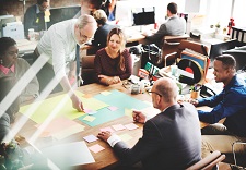 Photo of a bustling office space with workers collaborating in a shared space.